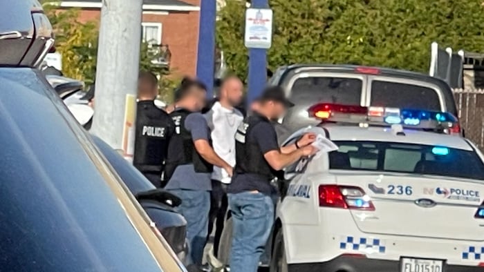 Le suspect relâché est entouré de policiers.