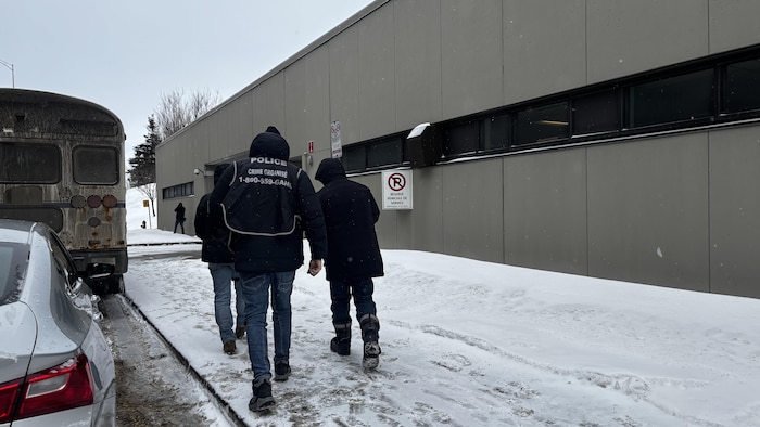 Des policiers escortent un homme vers le palais de justice de Québec
