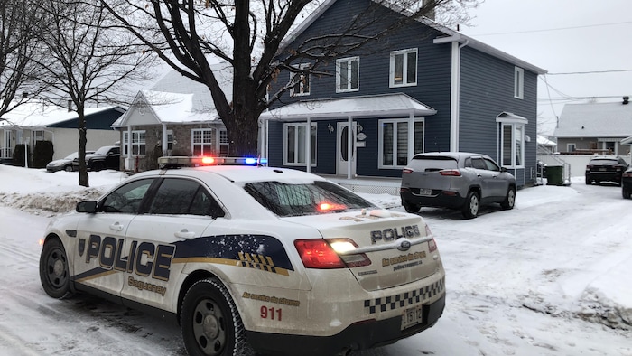 Une voiture de la police de Saguenay devant l'une des résidences perquisitionnées.