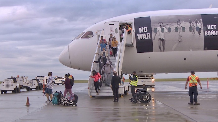 Un avion transportant près de 230 arrivants ukrainiens atterrit à l'aéroport de Regina, en Saskatchewan, le 4 juillet 2022.