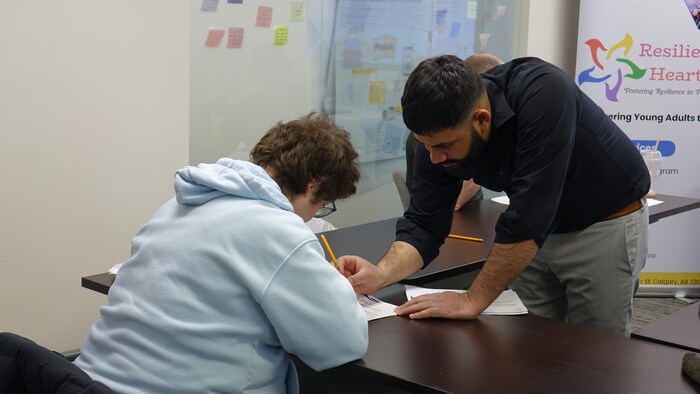 Arshdeep Sandhu aide une participante à remplir un document sur les différents types d'abus.