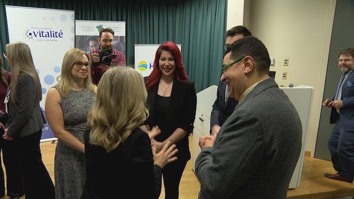 Des personnes, dont Arshia Haqani, entourent la première ministre Susan Holt.