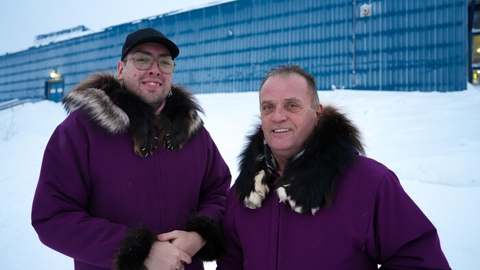 Portrait de Dustin Qaiyan Smith et de son conjoint dans leurs parkas dans un décor extérieur.