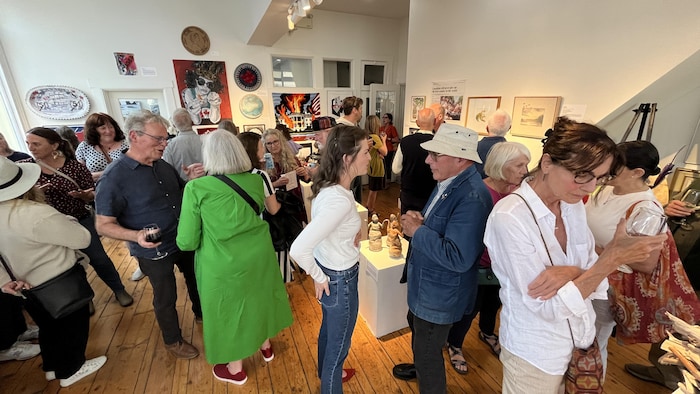 Une vingtaine de personnes visitent la galerie d'art de l'École d'art de Lunenburg pour le vernissage d'une exposition