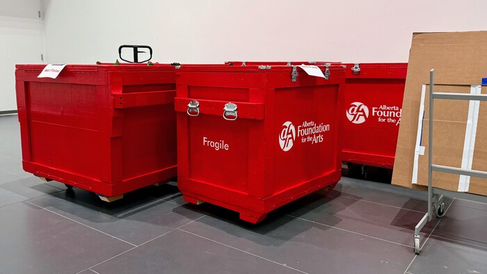 Des boîtes rouges pour transporter des œuvres d’art.