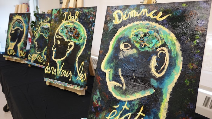 Des peintures sur des chevalets sur une table.
