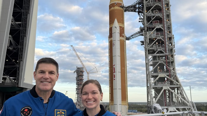 Les astronautes Jeremy Hansen et Jenni Gibbons posent devant la fusée S L S le 17 décembre 2025.