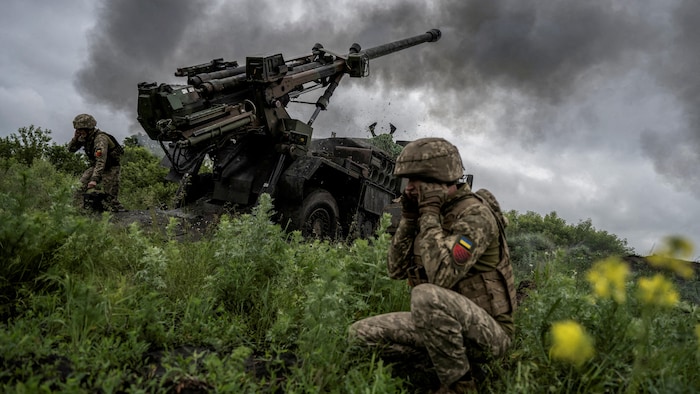 Un soldat se bouche les oreilles alors qu'un canon tire.