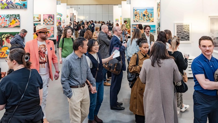 Une foule réunie dans une galerie d’art.