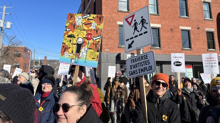Des gens brandissent des pancartes dans la rue.