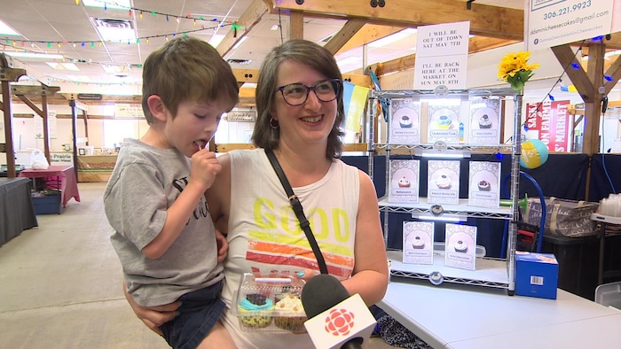 Une mère et son enfant avec une boîte de mini gâteaux au fromage.