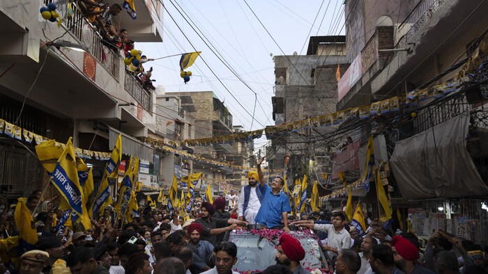 Arvind Kejriwal et le ministre en chef du Pendjab défilent dans les rues de New Dehli, devant leurs supporteurs, le 11 mai 2024.