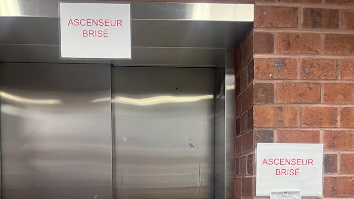 Une affiche «ascenseur brisé» sur une porte d'ascenseur.
