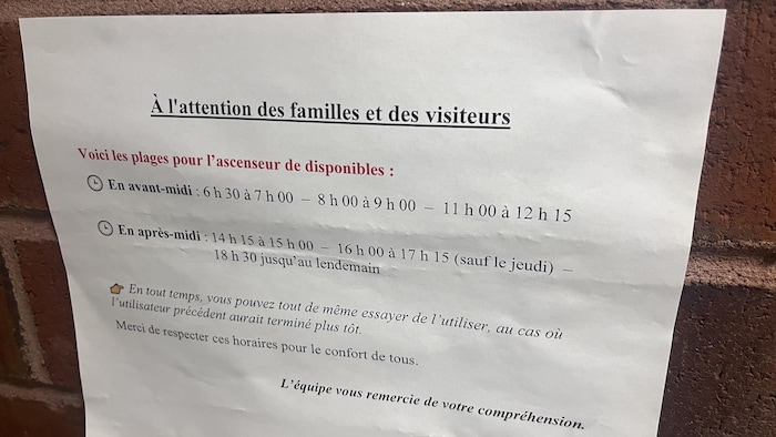 Une affiche à l'attention des familles indiquant les horaires de disponibilité de l'ascenseur.