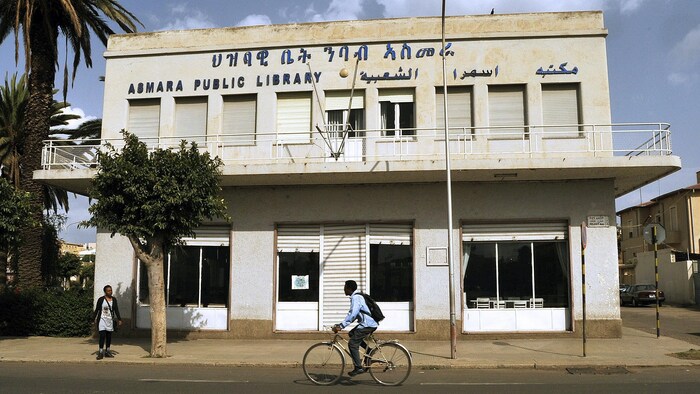 Un homme à vélo devant une bibliothèque publique d'Asmara. 