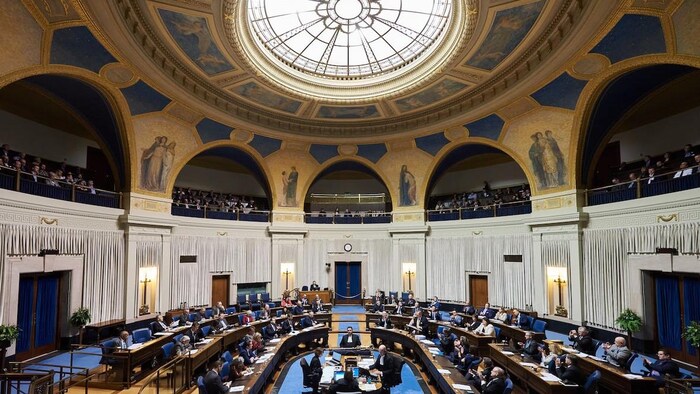 Les députés sont assis à l'intérieur de l'Assemblée législative du Manitoba.