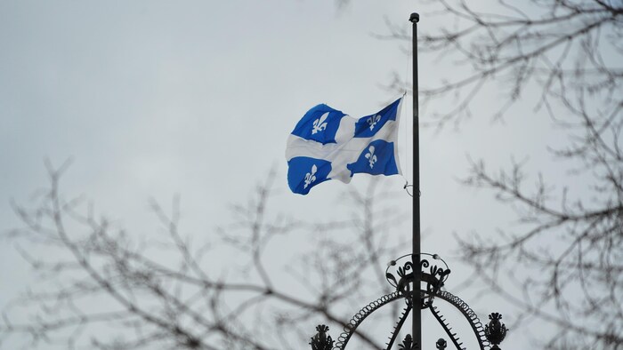Le drapeau du Québec en berne au-dessus de l'Assemblée nationale.
