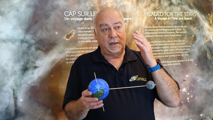 L'astronome explique le mouvement de la lune autour de la Terre.