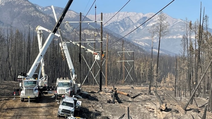 Des camions stationnés à un des endroits où les lignes de transmission électriques sont détruites. 