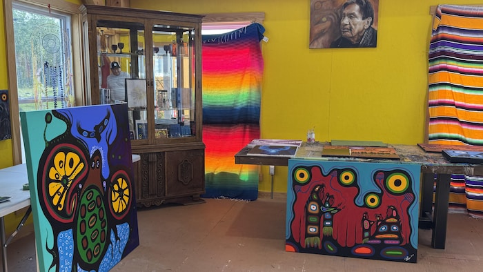 Plusieurs œuvres de style Woodland sont exposées dans un atelier aux murs colorés.