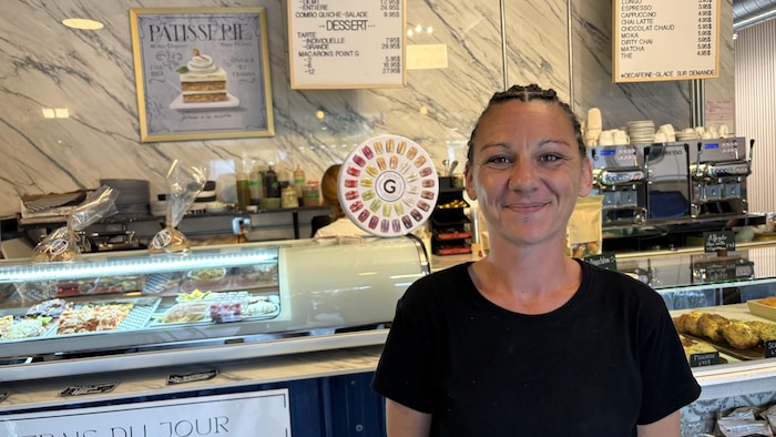 Léa Chabasse pose devant le comptoir de la boulangerie. 