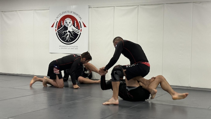 Des athlètes pratiquent le jiu-jitsu.