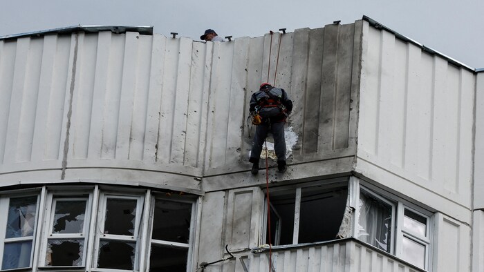 Des ouvriers réparent les dommages sur le toit d'un immeuble à Moscou à la suite d'une attaque de drones, en Russie, le 30 mai 2023.