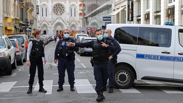 Quatre policiers se tiennent dans la rue.