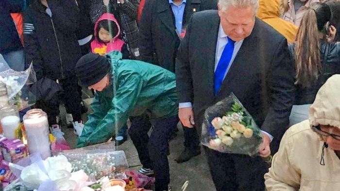 Doug Ford dépose un bouquet de roses. 