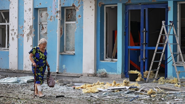 Une femme passe devant le bâtiment endommagé d'une banque, lors d'une attaque de drones ukrainiens menée pendant la nuit à Belgorod, selon les autorités locales.