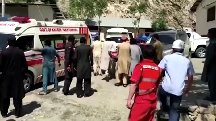 Capture d'écran d'une vidéo de gens poussant une civière près d'une ambulance.