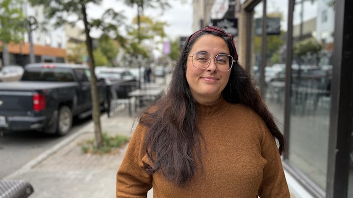 Audrey Desrochers pose sur l'avenue Principale à Rouyn-Noranda, souriante.