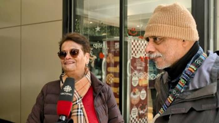 Audrey et Simon Athaide devant les portes du Centre Eaton de Toronto.