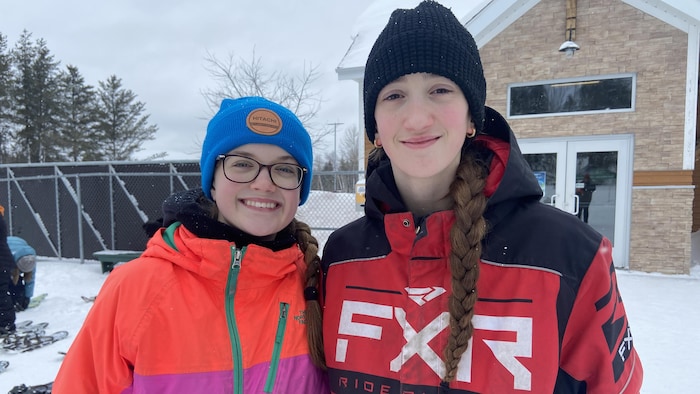 Audrina Levasseur pose à côté de Zaya Coulombe dans une cour enneigée. 
