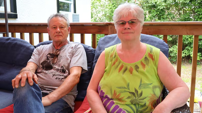 Un homme et une femme assis côte à côte dans un endroit aéré.
