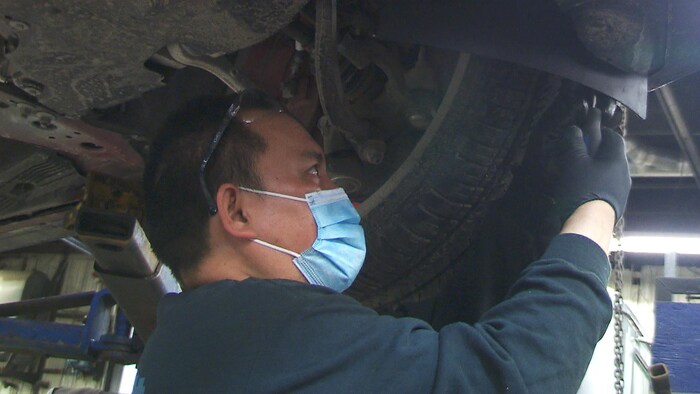 Un mécanicien en train d'inspecter la roue d'un véhicule.