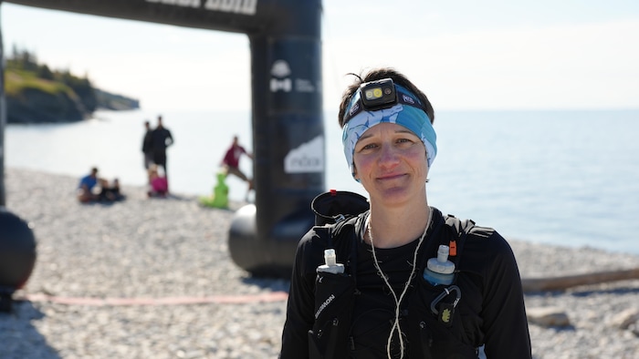 Portrait de Aurélie Bellet, portant encore son équipement de course, près de la ligne d'arrivée.