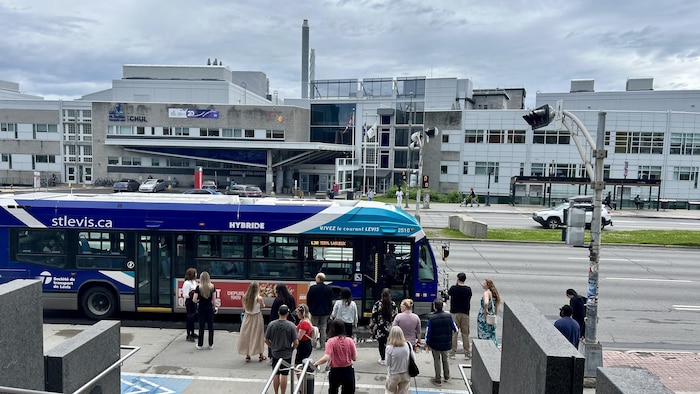 Un bus prend des clients devant le CHUL.