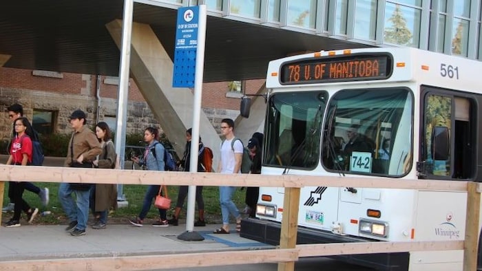 Des étudiants descendent d'un autobus.