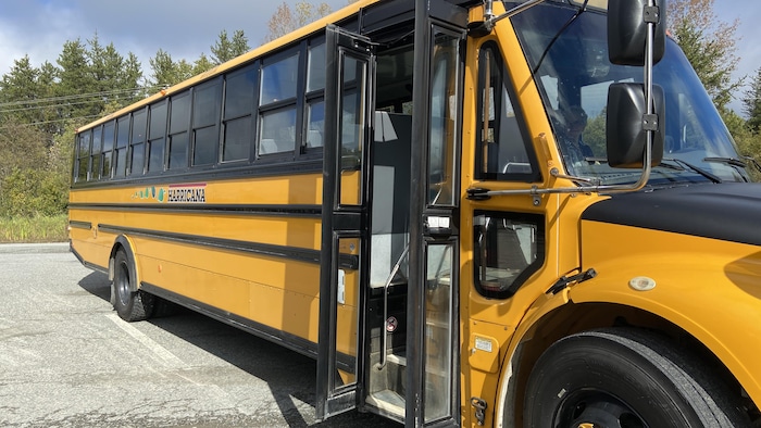 Le chauffeur d'un autobus scolaire ouvre les portes.