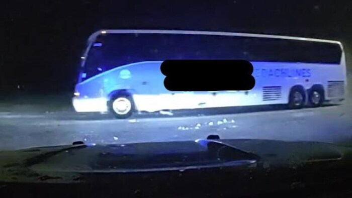 L'autobus sur une route enneigée la nuit.