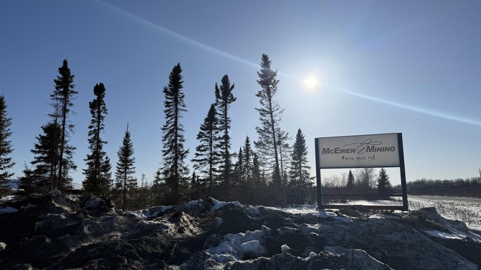 Le panneau McEwen Mining au milieu des arbres.