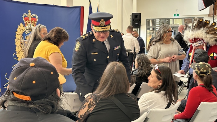 Le chef de la police d'Edmonton Dale McFee saluant des personnes assises.