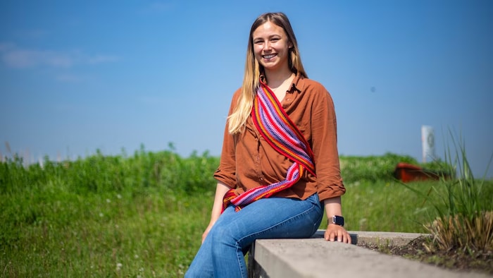 Une jeune femme porte une ceinture fléchée.