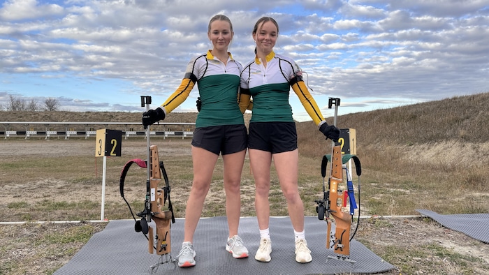 Ava Darbellay et Emily Klym montrent leur carabine de biathlon.