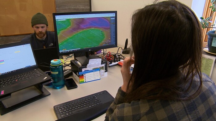 Une préventionniste devant un ordinateur où se trouve une carte météo.