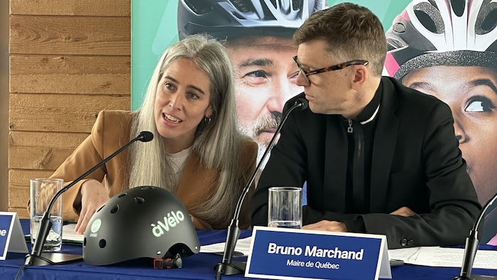 La présidente du RTC, Maude Mercier Larouche, et le maire de Québec, Bruno Marchand, assis, en conférence de presse pour le service àVélo. 