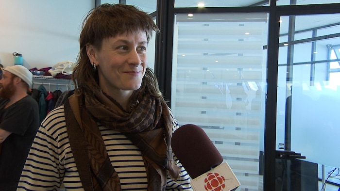 Capture d'écran d'une entrevue avec Ariane Brault, résidente de Trois-Pistoles, souriante et arborant un foulard.