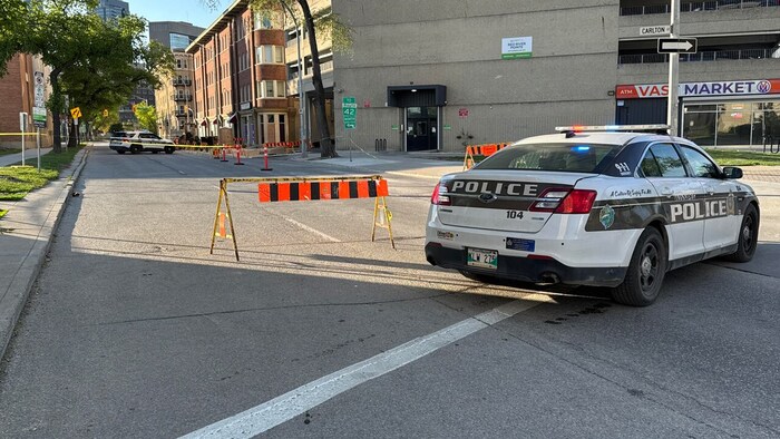 Une voiture de police et des barrières bloquent l'avenue Cumberland.