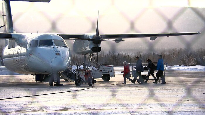 Passagers qui embarquent dans un avion à l'aéroport de Gaspé.